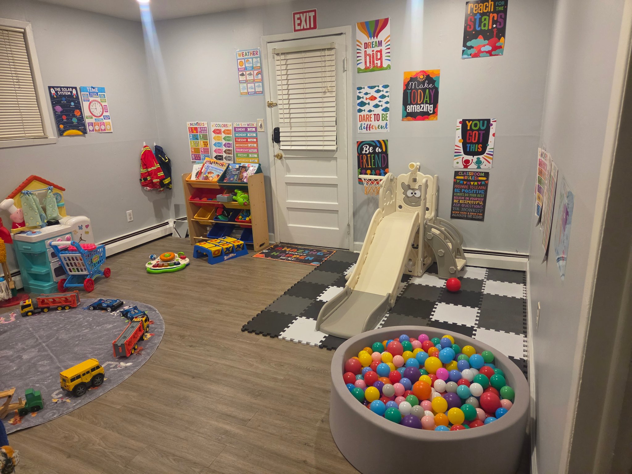 Bright play room with slide, ball pit, toys and educational posters at Taylor's Bright Beginners
